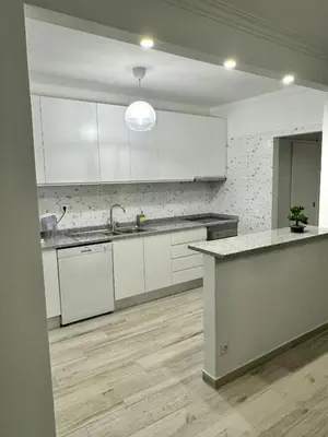a kitchen with white cabinets and a counter top at Princess Retreat Beautiful Modern Aprt 2 min walk from Quarteira Beach in Quarteira