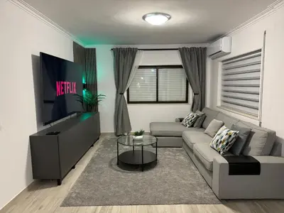 a living room with a couch and a tv at Princess Retreat Beautiful Modern Aprt 2 min walk from Quarteira Beach in Quarteira