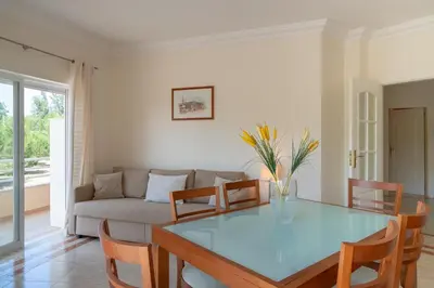 a living room with a glass table and a couch at VILAMOURA Two Bedroom Near Praia Falésia in Quarteira
