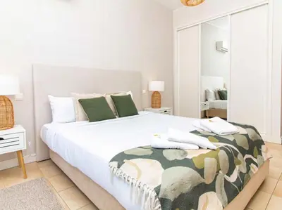 a bedroom with a large white bed with green pillows at Serenity 06 House by Stay ici Algarve Holiday Rental in Albufeira