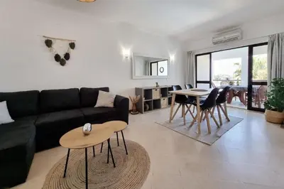 a living room with a black couch and a table at Blue Palmtree in Albufeira