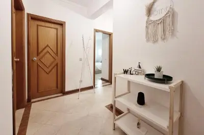 a room with a door and a table and a hallway at Blue Palmtree in Albufeira