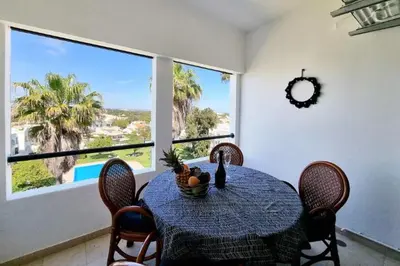 a dining room with a table and chairs and a large window at Blue Palmtree in Albufeira