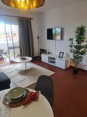 a living room with a table and a tv at S Soares T1 Sil Choro in Albufeira
