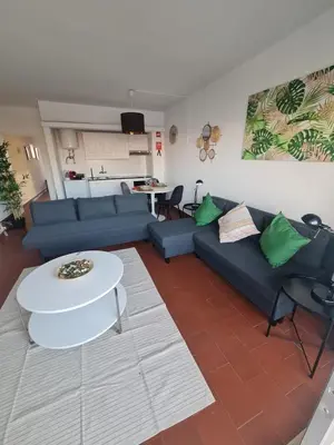 a living room with a blue couch and a table at S Soares T1 Sil Choro in Albufeira