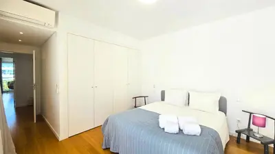 a white bedroom with a bed with two towels on it at Segolene Design in Albufeira
