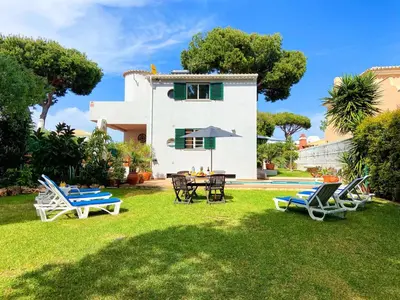 a villa with a yard with chairs and a table at Villa Sarah by BeCherish in Quarteira