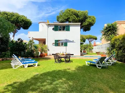 a house with a yard with chairs and a table at Villa Sarah by BeCherish in Quarteira