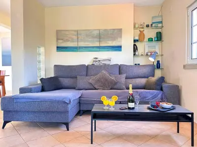 a living room with a blue couch and a table at Villa Sarah by BeCherish in Quarteira
