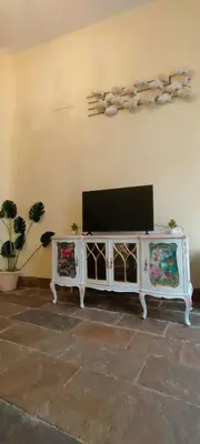 a white entertainment center with a television in a living room at Grand Studio 52 in Faro