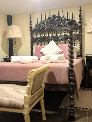 a bedroom with a bed and a chair and a bed with pink sheets at Grand Studio 52 in Faro
