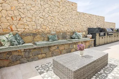 a bedroom with a bed and a table with a mirror at Villa Moroz - BY BEDZY in Almancil