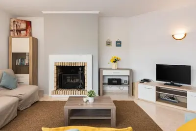 a living room with a couch and a fireplace at Casa Luna with Saltwater Pool in Olhos de Água