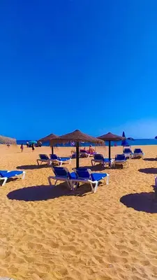 a group of chairs and umbrellas on a beach at Casa Luna with Saltwater Pool in Olhos de Água