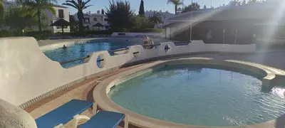 a swimming pool with a slide in a resort at Casa de Praia em São Rafael in Albufeira