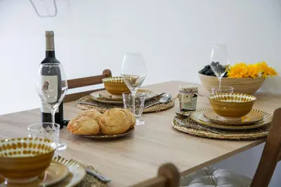 a table with plates of food and a bottle of wine at Amelie Old Town Apartment in Albufeira