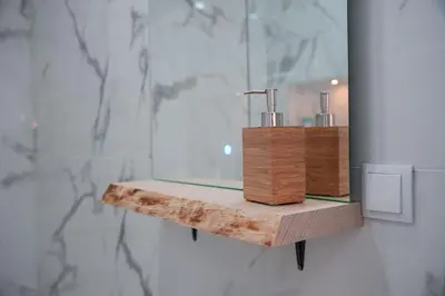 a bathroom with a wooden shelf with a mirror at Amelie Old Town Apartment in Albufeira