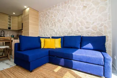 a blue couch with yellow pillows in a living room at Amelie Old Town Apartment in Albufeira