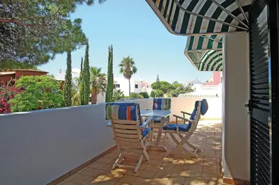 a table and chairs on a patio with an umbrella at VM Relax Beautiful villa with pool! VILAMOURA! in Quarteira