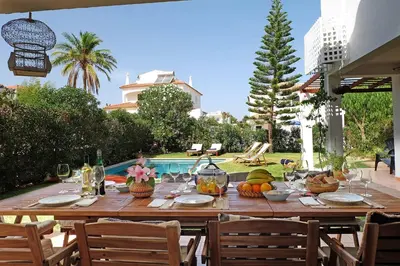 a wooden table with fruit and wine glasses on it at VM Relax Beautiful villa with pool! VILAMOURA! in Quarteira