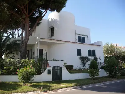 a white house with a tree in front of it at VM Relax Beautiful villa with pool! VILAMOURA! in Quarteira