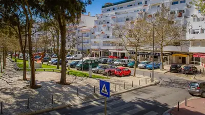 a city street with cars parked in a parking lot at La Liberdad Loft in Albufeira