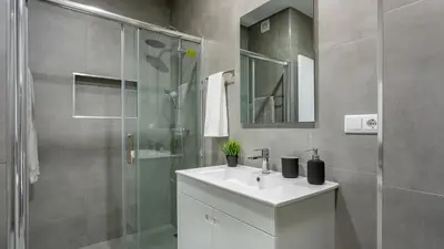 a bathroom with a sink and a glass shower at La Liberdad Loft in Albufeira