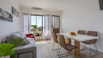 a living room with a white table and chairs at Pateo Loft in Albufeira