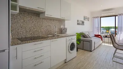 a kitchen with a sink and a washing machine at Pateo Loft in Albufeira
