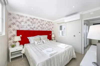 a bedroom with a large bed with a red headboard at Stunning 2-Bedroom Beach Retreat in Vale do Lobo in Almancil