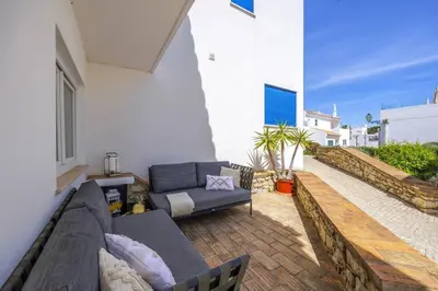 a living room with a couch and a table on a patio at Stunning 2-Bedroom Beach Retreat in Vale do Lobo in Almancil