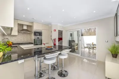 a kitchen with a large island with bar stools at Stunning 2-Bedroom Beach Retreat in Vale do Lobo in Almancil