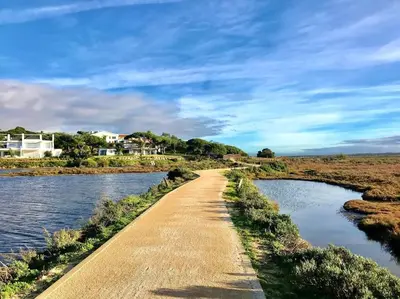 a dirt road next to a body of water at Stunning 2-Bedroom Beach Retreat in Vale do Lobo in Almancil