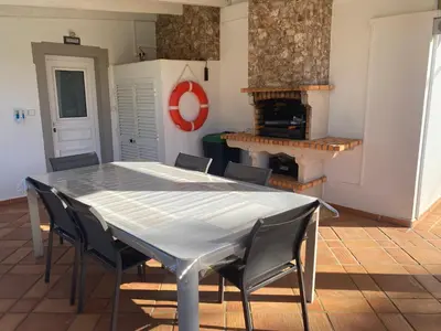 a table and chairs in a room with a fireplace at Villa Albufeira 1 à 6 personnes in Guia
