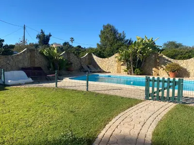 a fence around a swimming pool in a yard at Villa Albufeira 1 à 6 personnes in Guia