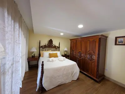 a bedroom with a large bed and a wooden cabinet at Grand Studio 27 in Faro