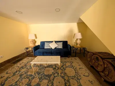 a living room with a blue couch and a rug at Grand Studio 27 in Faro