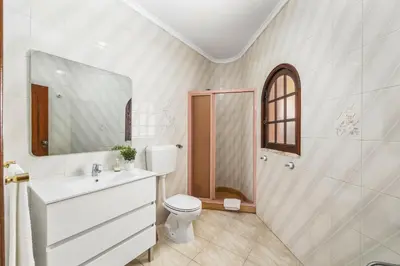 a bathroom with a toilet and a sink and a shower at Villa Vista Mar by Villa Plus in Terras Novas