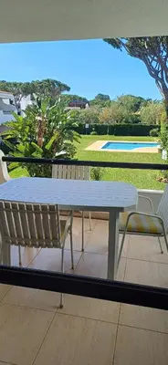 a table and chairs on a balcony with a view of a pool at AA Apartamento Solar dos Pinheiros in Vilamoura