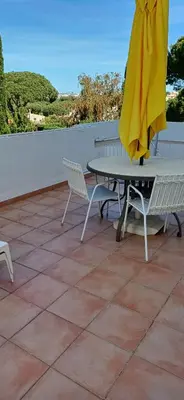 a table and chairs and an umbrella on a patio at AA Apartamento Solar dos Pinheiros in Vilamoura