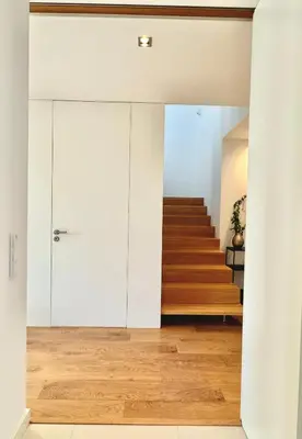 a room with white cabinets and a staircase with wooden floors at Narciso Townhouse in Faro