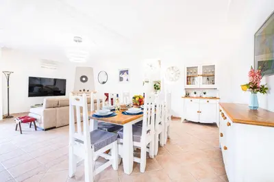 a kitchen and living room with a table and chairs at Villa Los Angeles by Algarve Vacation in Boliqueime