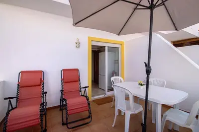 a dining room with a table and chairs and an umbrella at V2 a 400 m da Praia da Falésia in Albufeira