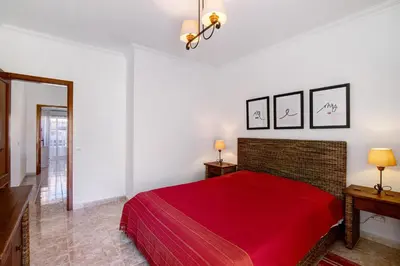 a bedroom with a red bed with two tables and two lamps at V2 a 400 m da Praia da Falésia in Albufeira