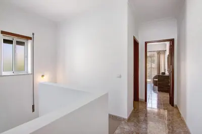 a hallway of a house with white walls and a window at V2 a 400 m da Praia da Falésia in Albufeira