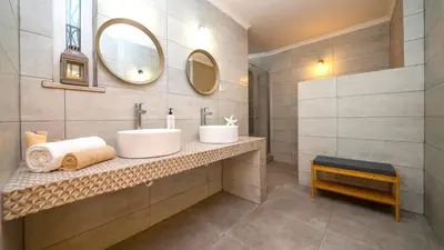 a bathroom with two sinks and a mirror at Villa Del Sol by Algarve Vacation in Quarteira