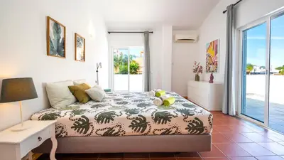 a bedroom with a bed and a view of the ocean at Villa Del Sol by Algarve Vacation in Quarteira