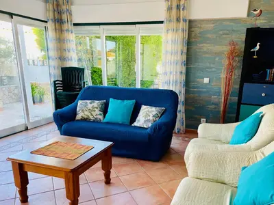 a living room with a blue couch and a coffee table at Villa Cristipaulo in Praia de Faro