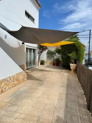 a patio with a yellow umbrella on a building at Villa Cristipaulo in Praia de Faro