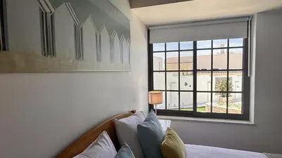 a bedroom with a bed and a large window at Buganvilia by Check-in Portugal in Albufeira
